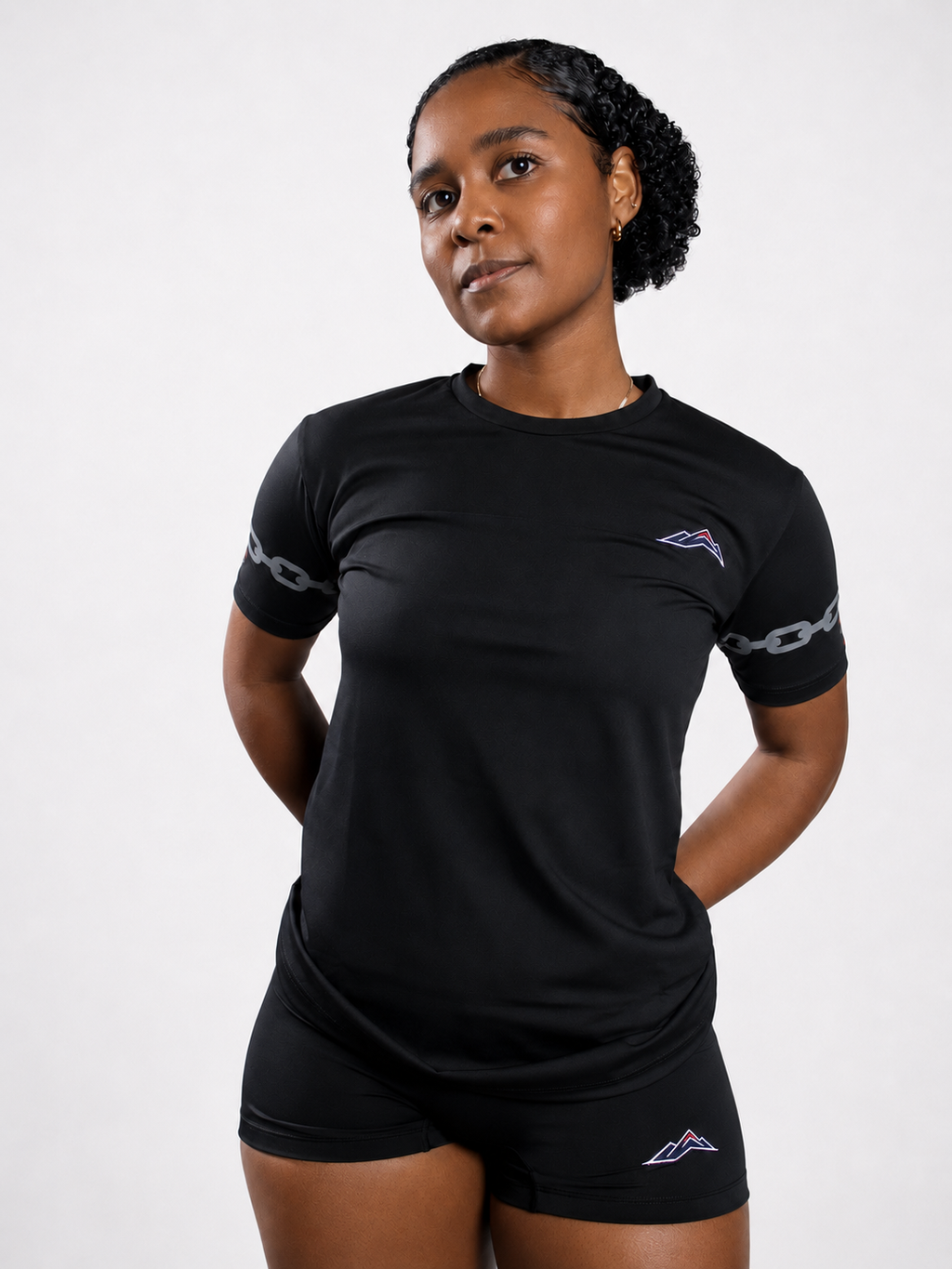 MÒN The Cost Tee in black, front standing view with embroidered mountain logo