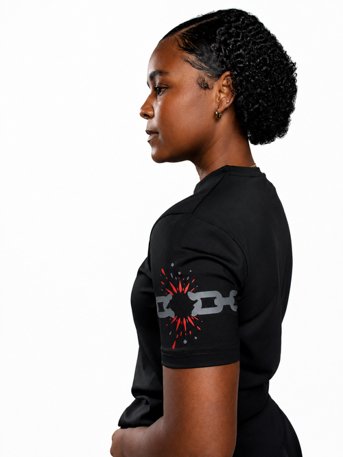 MÒN The Cost Tee in black, side profile close-up of broken-chain sleeve graphic
