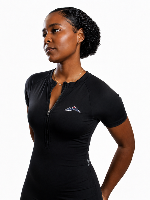 MÒN The Break Through Romper in black, front view with embroidered mountain logo